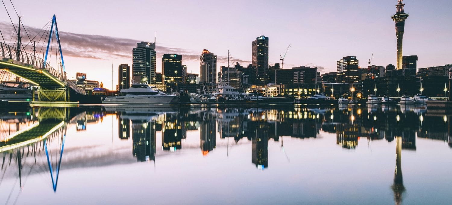 City skyline at dusk reflecting on water in a harbor