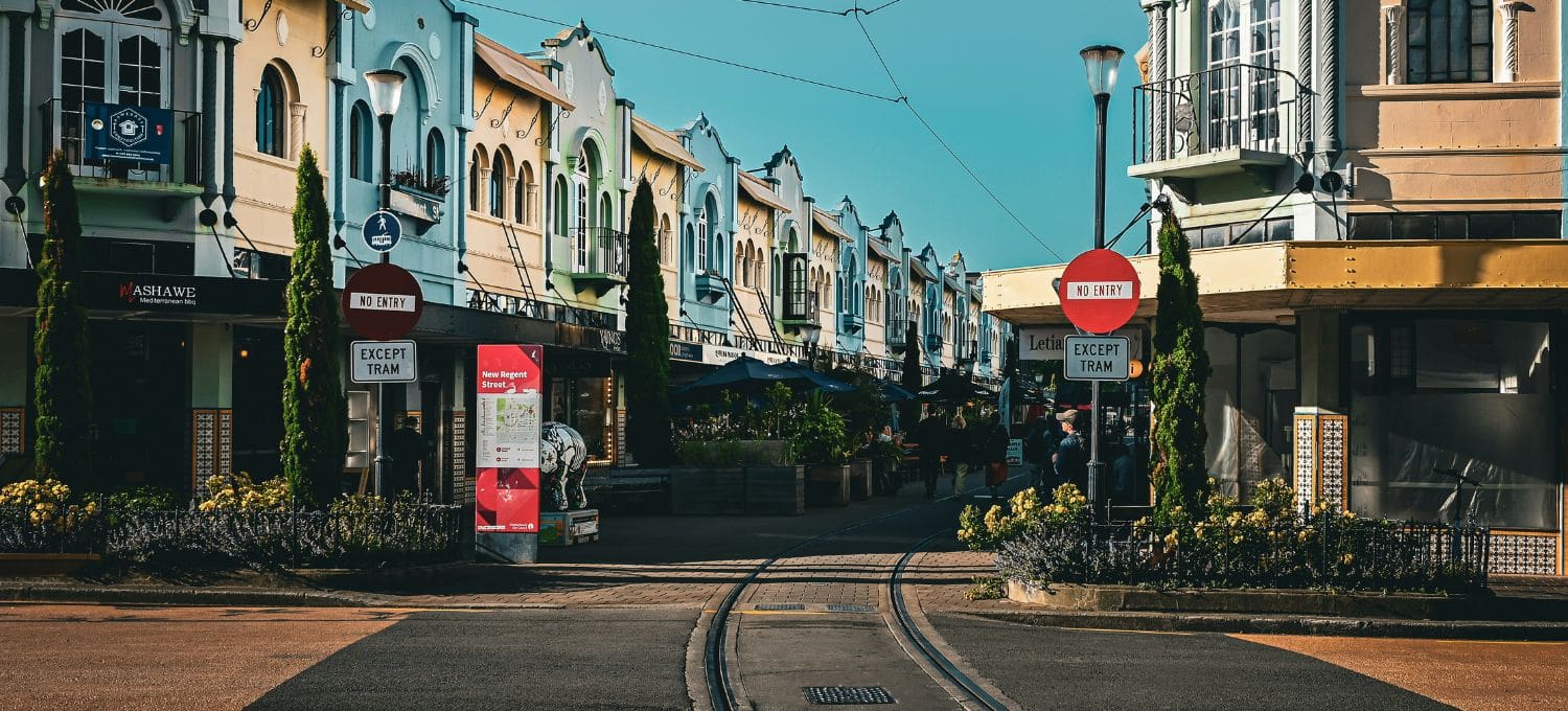 Streetcar tracks leading down a road with brightly colored buildings on the sides of the street