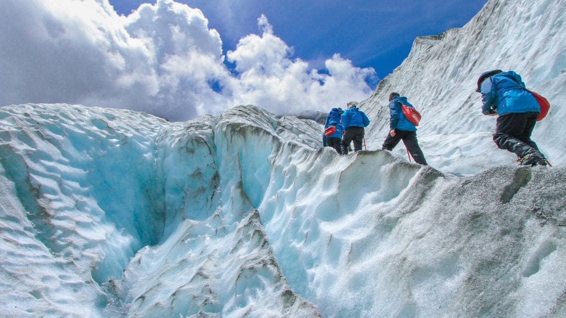 Four hikers walking up a glacier