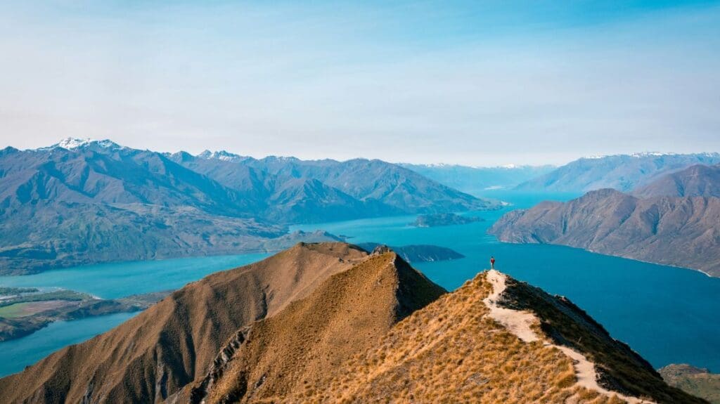 Rugged mountain range with hiking trail, lake in the background and more mountains