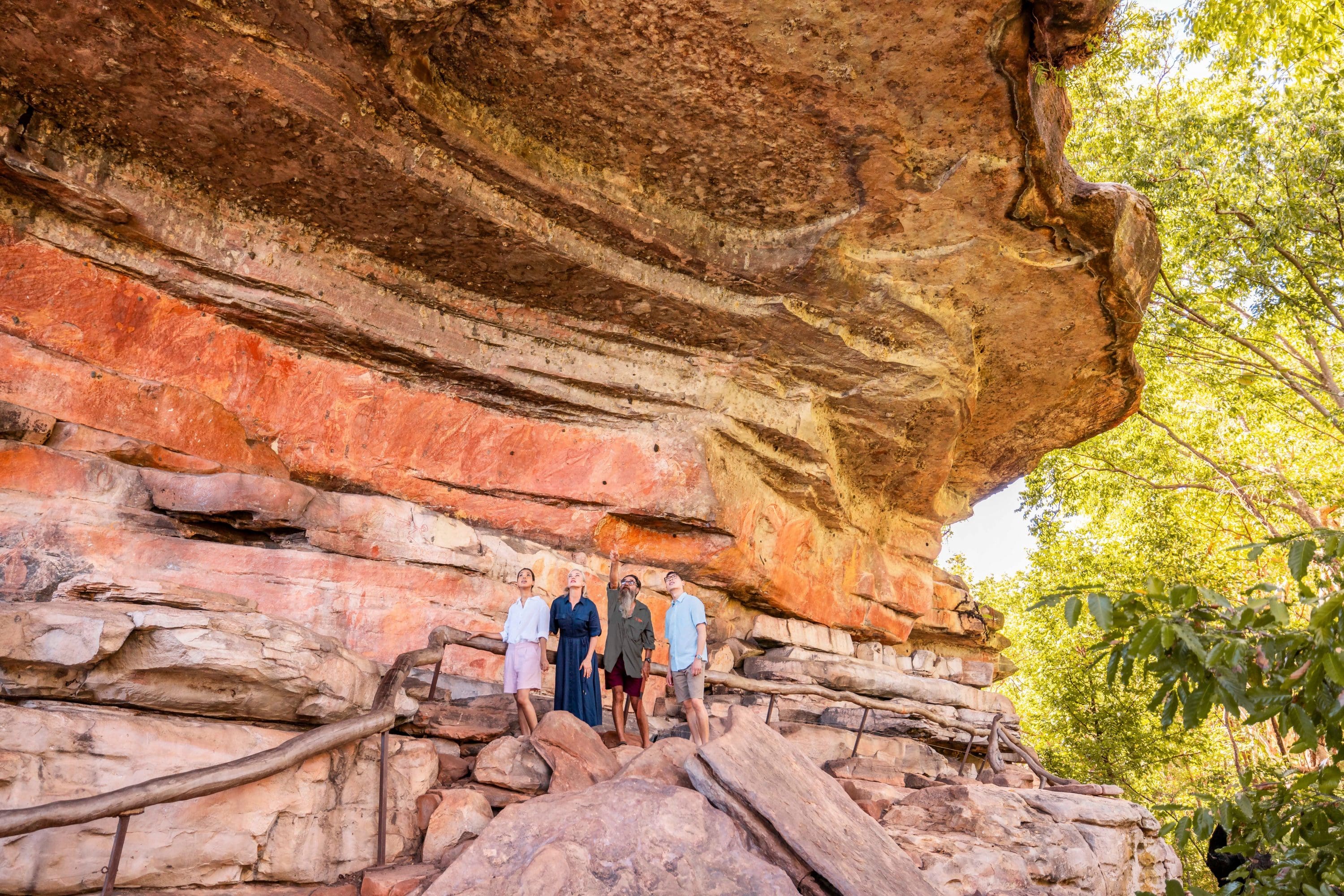 People in a rocky area with a large rock outcropping