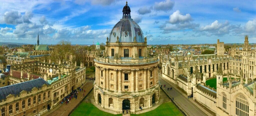 Aerial view of a historic cityscape with a prominent circular library building in the center, under a clear blue sky, conveying a serene atmosphere.