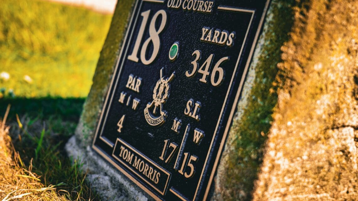 Close-up of the 18th hole sign on a golf course, marked "Old Course." It shows 346 yards, par 4. Sunlight adds a warm, nostalgic feel.