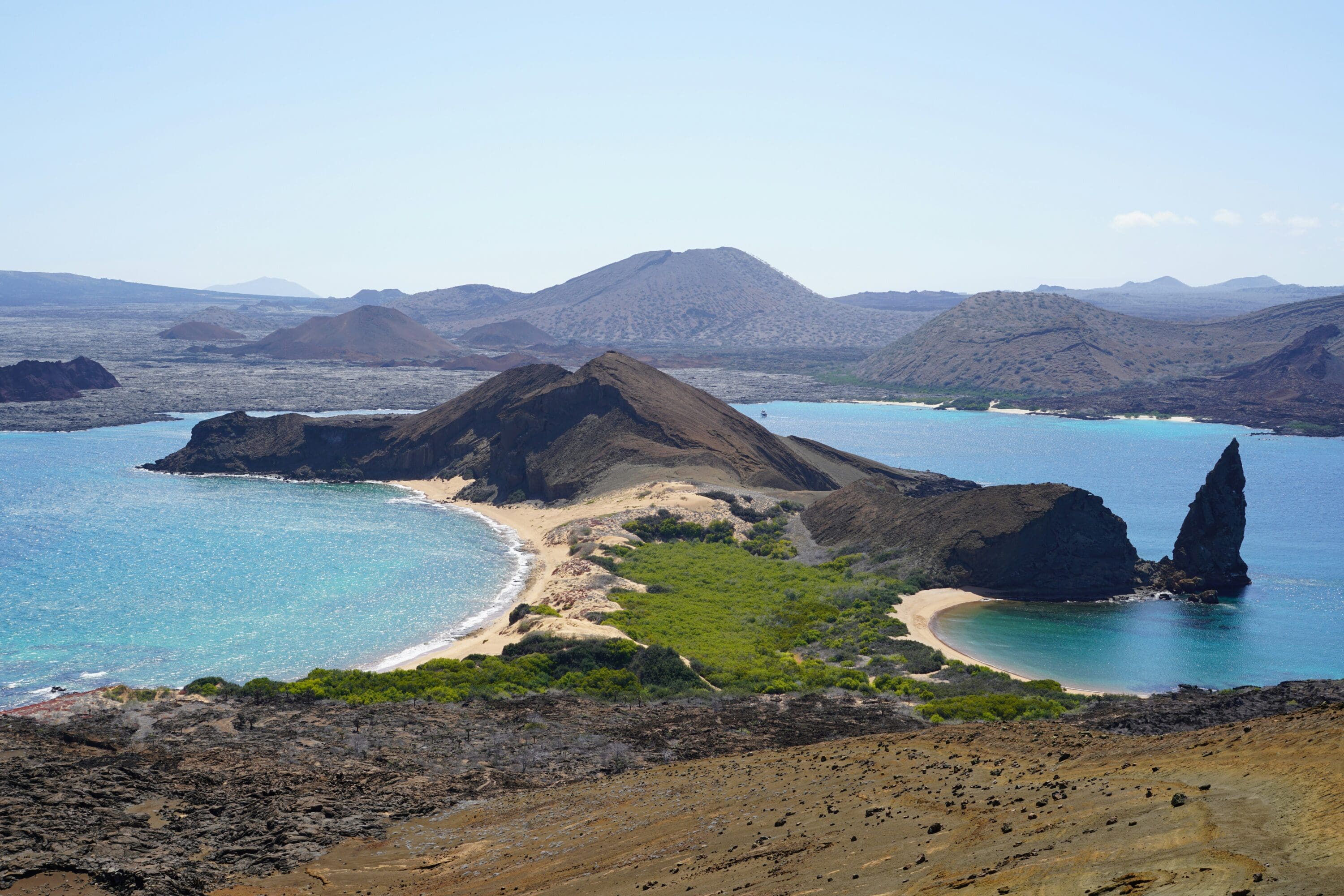 an island with a sandy beach and blue water