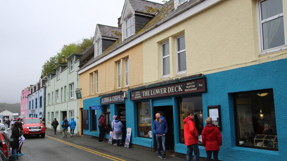 people walking the street in front of local storefronts