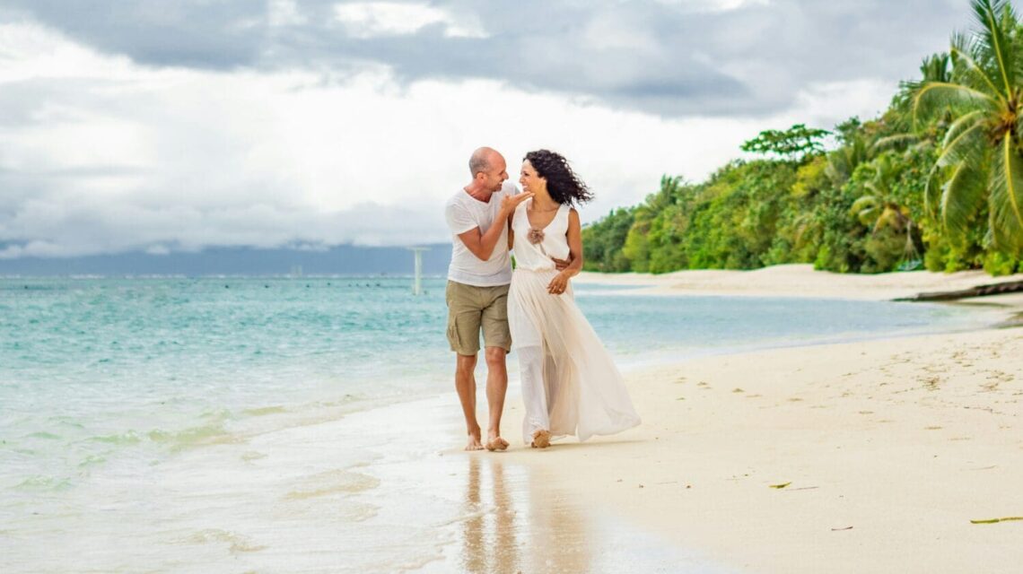man and woman standing on a tropical beach during daytime