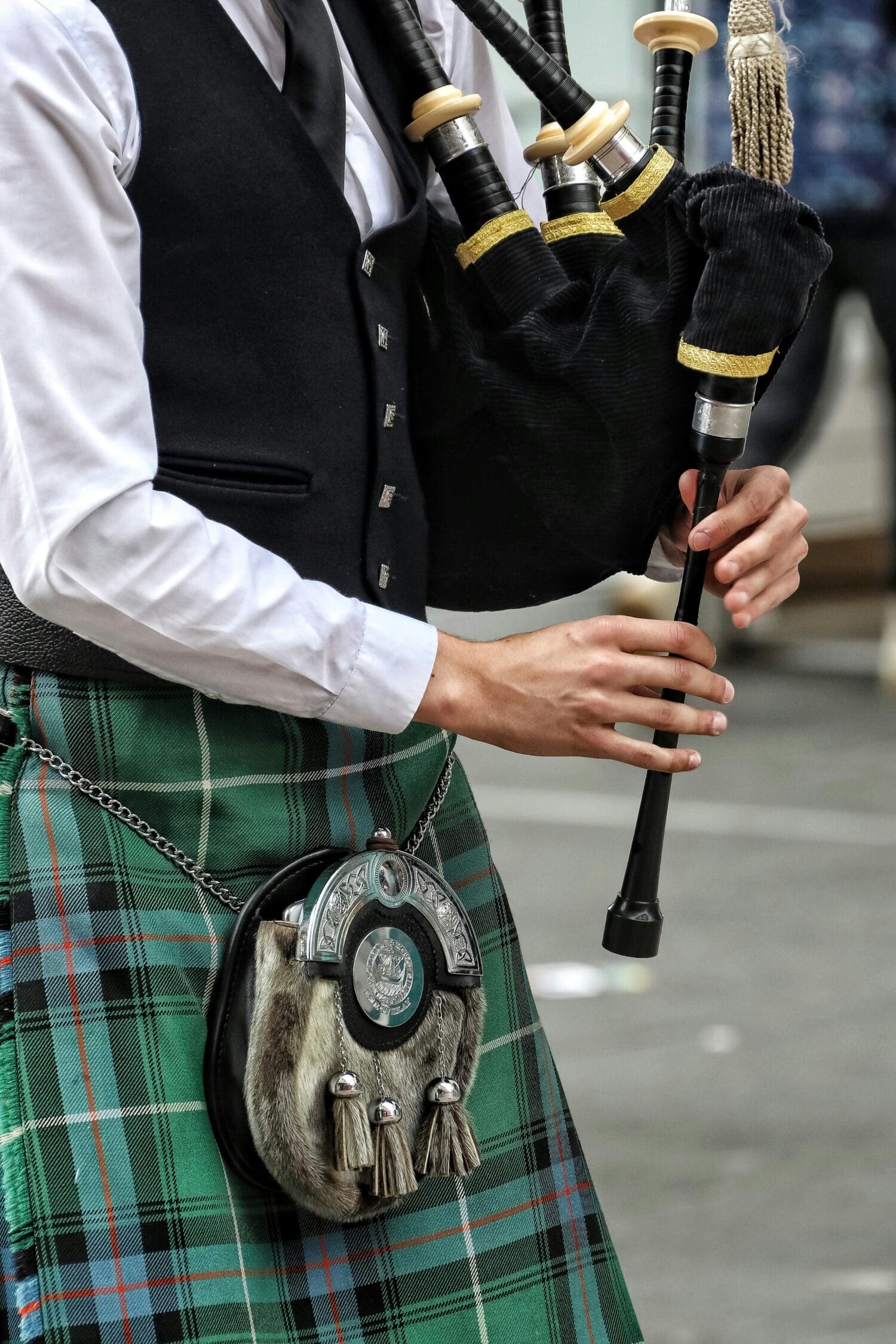 Close up image of a bagpiper playing for a Glasgow crowd